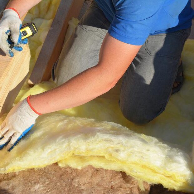 worker installing the atic insulation